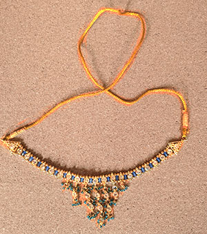 an ornate necklace of gold with an alternating pattern of sapphires and diamonds